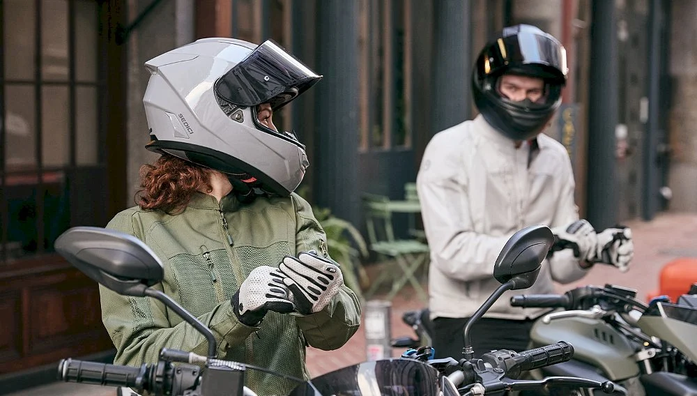 Two riders putting on their helmets and gloves before a ride
