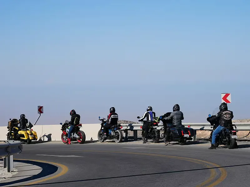 Riders pulled over at a mountain overlook along a UAE riding road